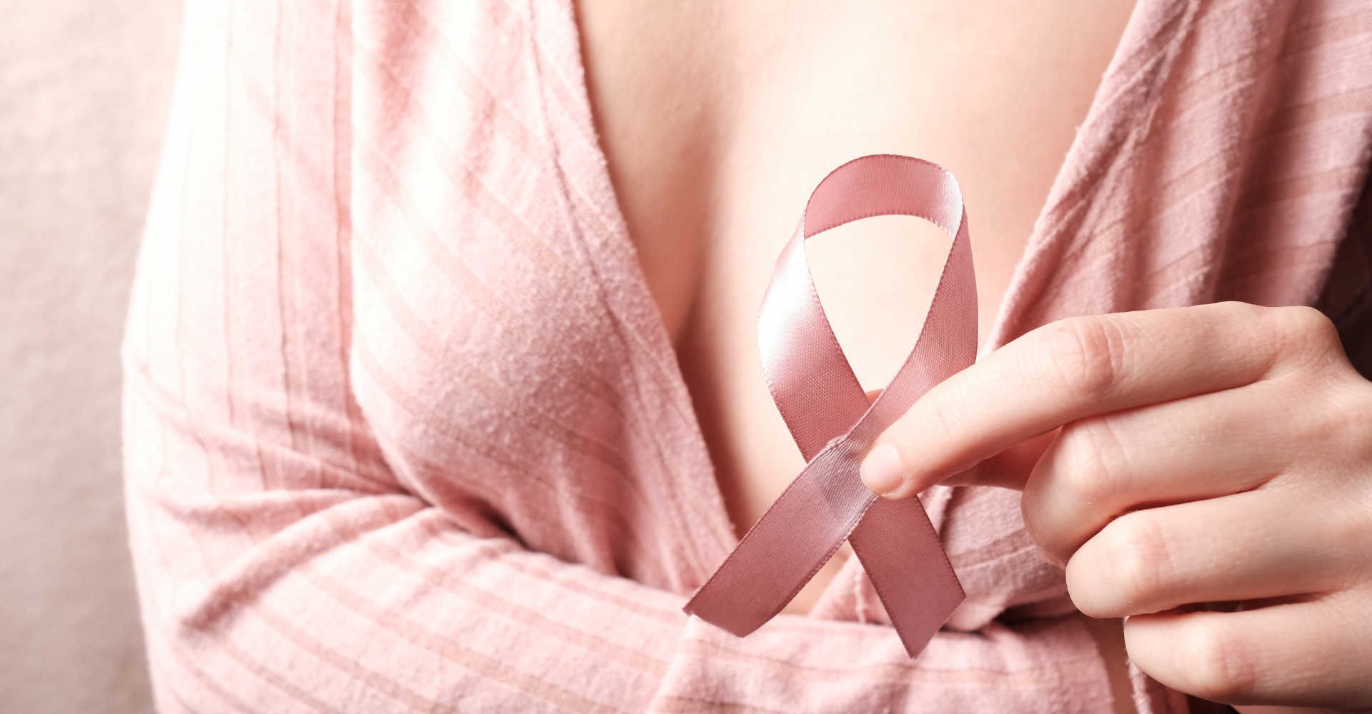 Modelo branca segurando laço de outubro rosa