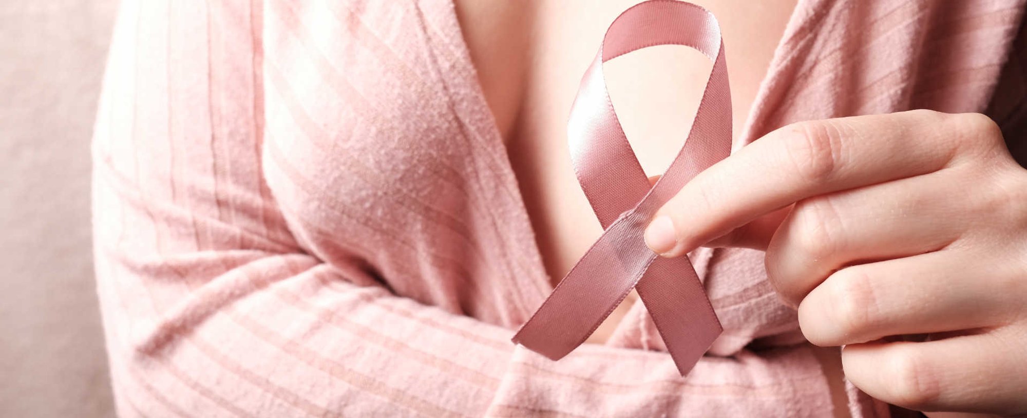 Modelo branca segurando laço de outubro rosa