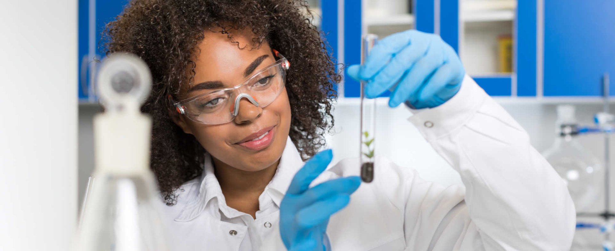Modelo negra vestida de cientista com jaleco branco