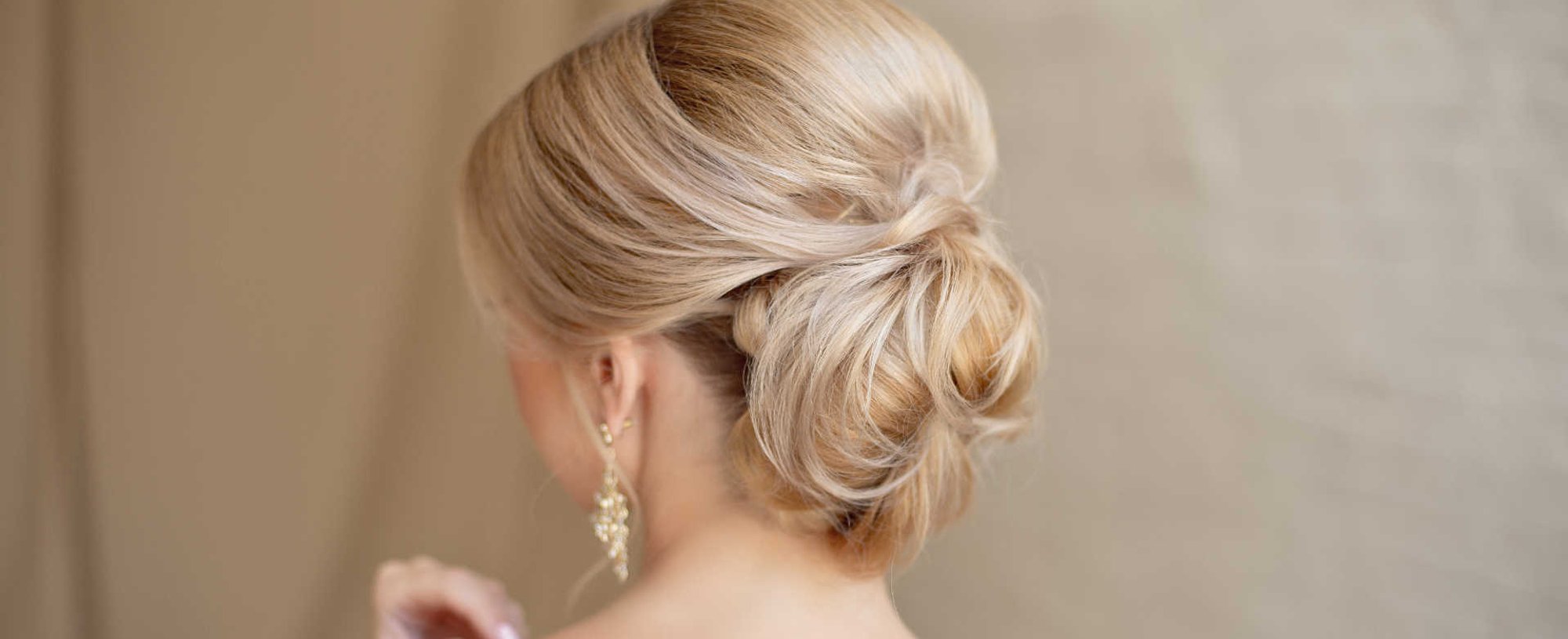 Modelo loira de costas com penteado coque