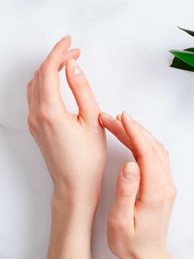 Imagem de uma mão branca com produtos ao lado