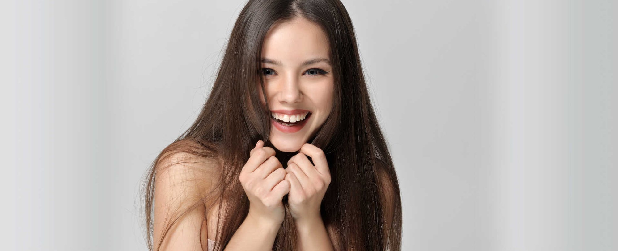 Modelo branca sorrindo com cabelo liso