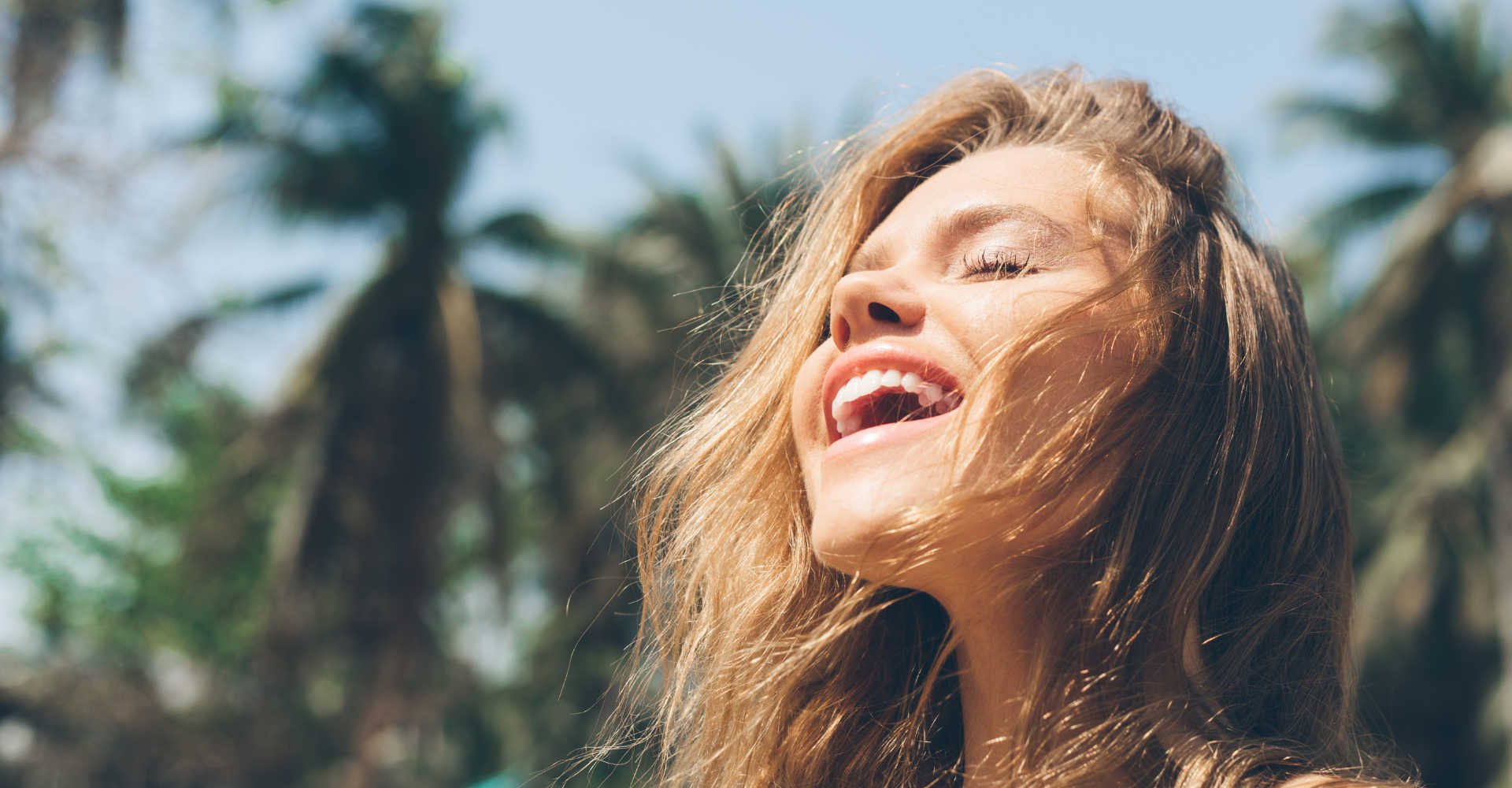 Modelo branca com os olhos fechados e expressão de felicidade no rosto