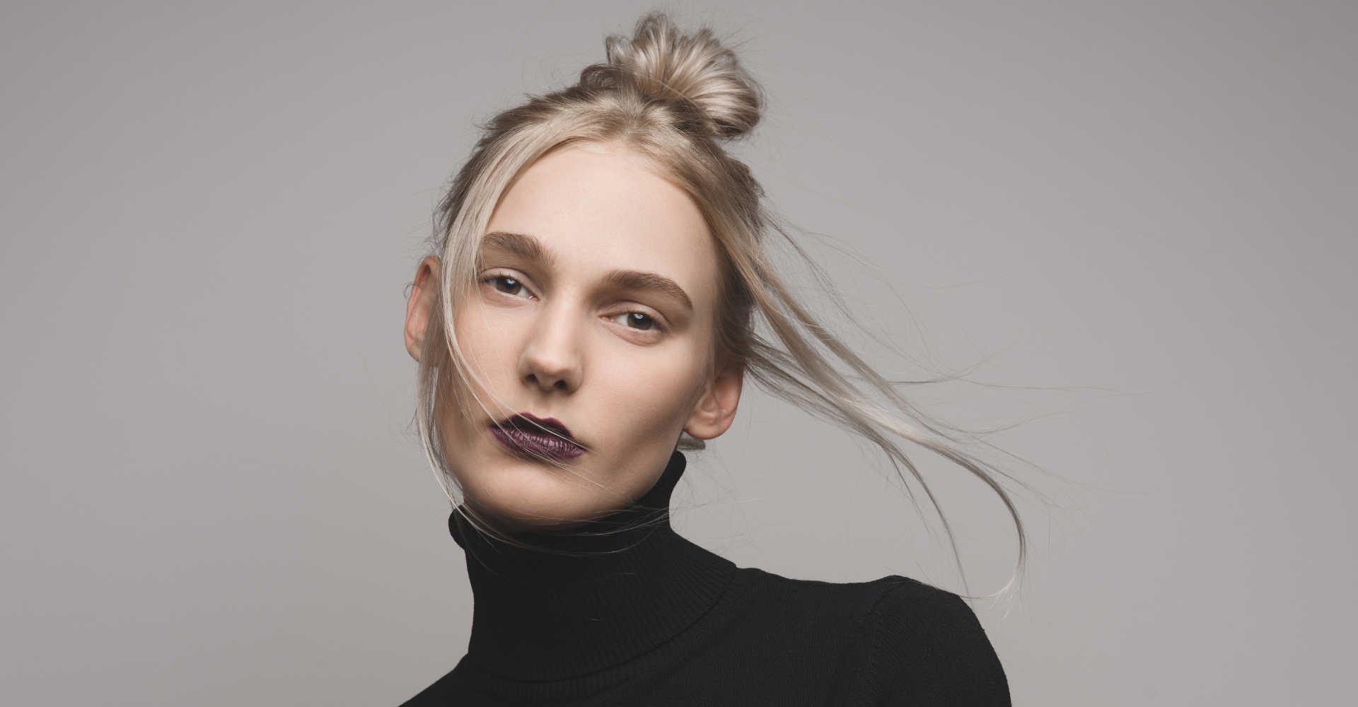 Modelo branca com coque loiro posando para a foto