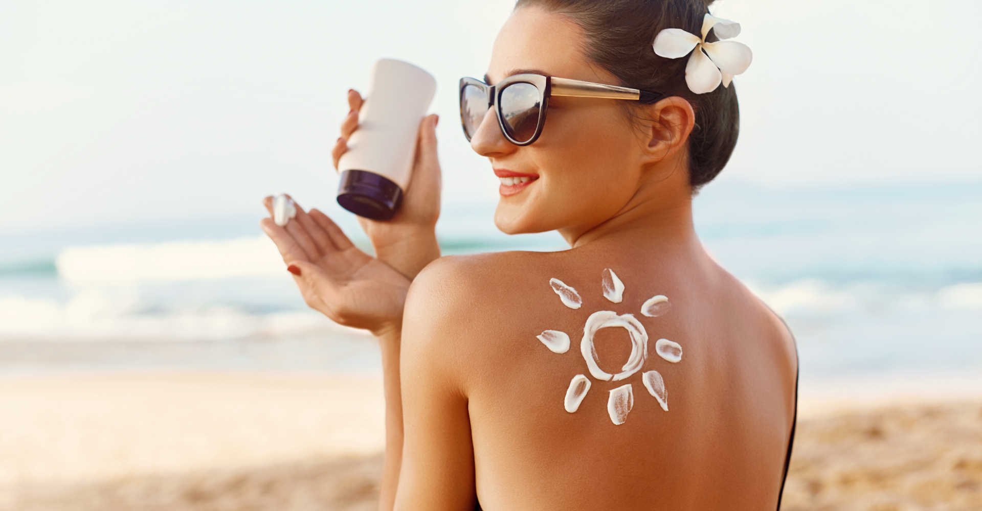 Modelo branca passando protetor solar nas costas