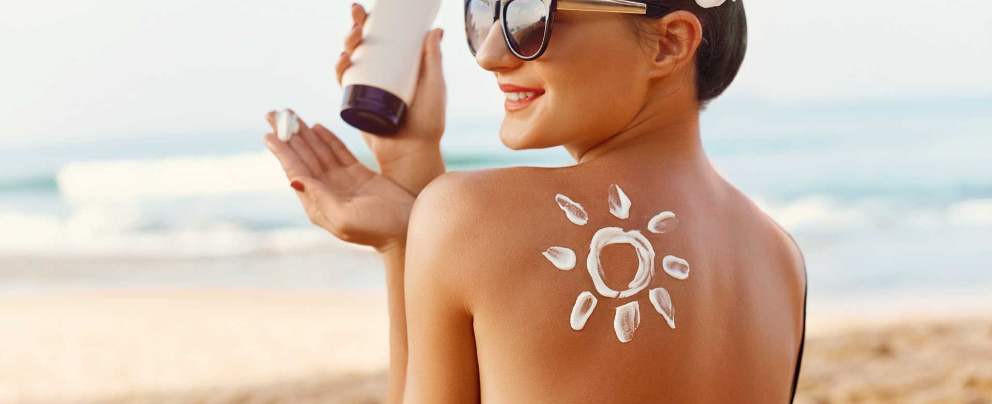 Modelo branca passando protetor solar nas costas