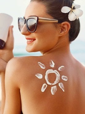 Modelo branca passando protetor solar nas costas