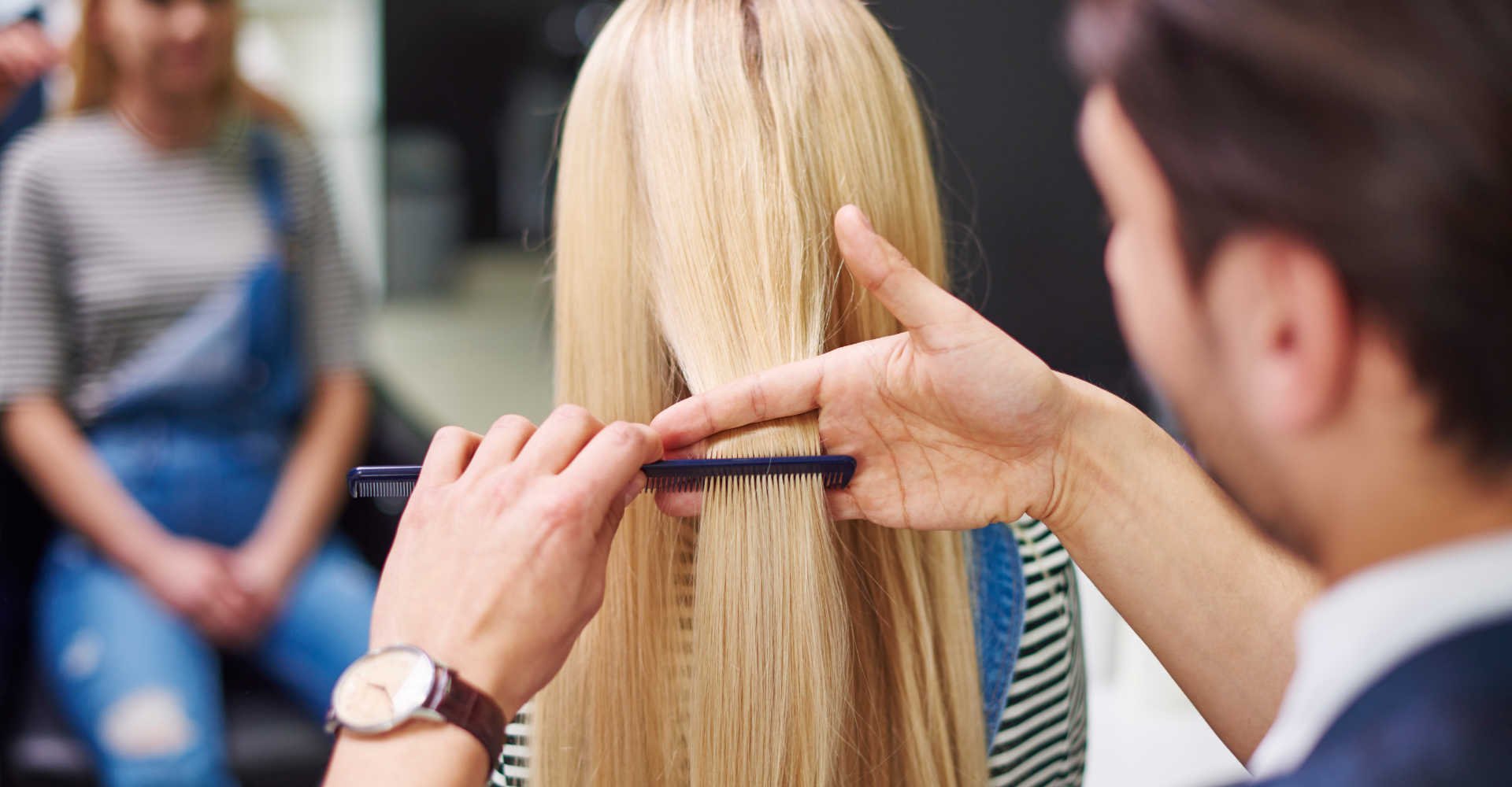 Profissional cortando o cabelo de modelo loira