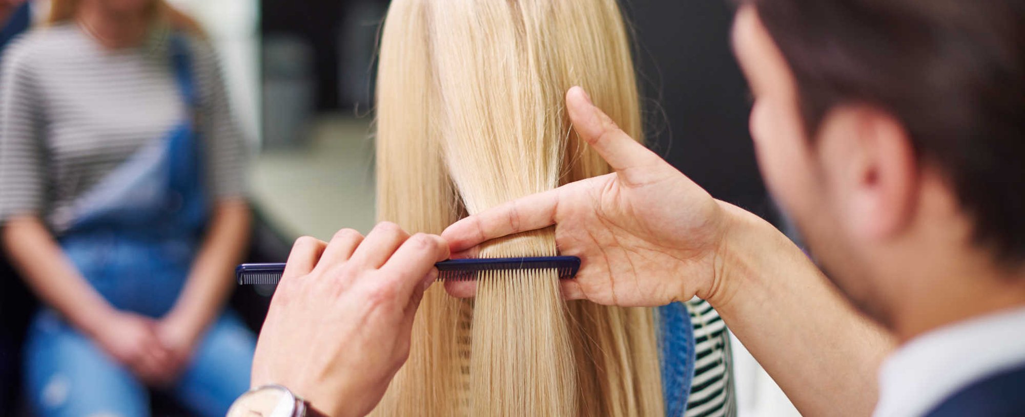 Profissional cortando o cabelo de modelo loira