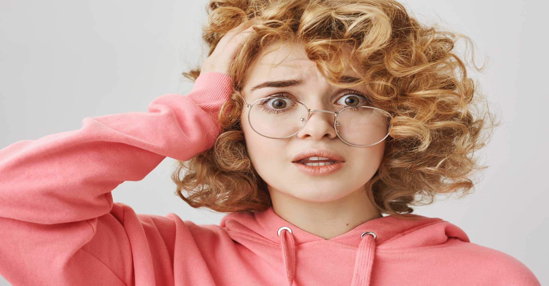 Modelo branca de óculos com a mão no cabelo
