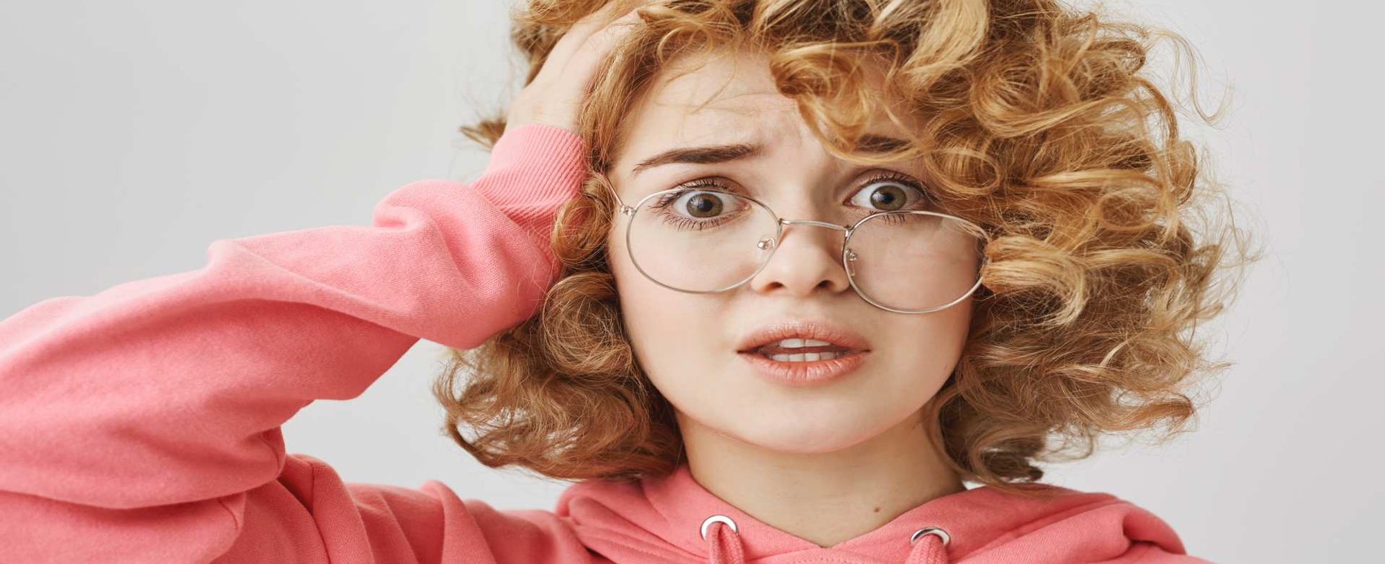 Modelo branca de óculos com a mão no cabelo