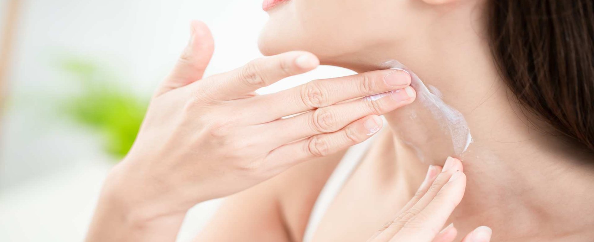 Modelo branca passando protetor solar no pescoço