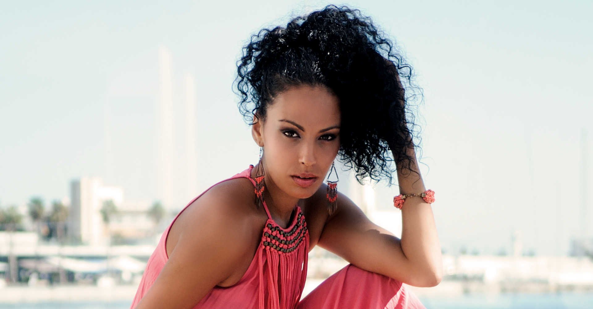 Modelo negra com cabelo cacheado posando para foto