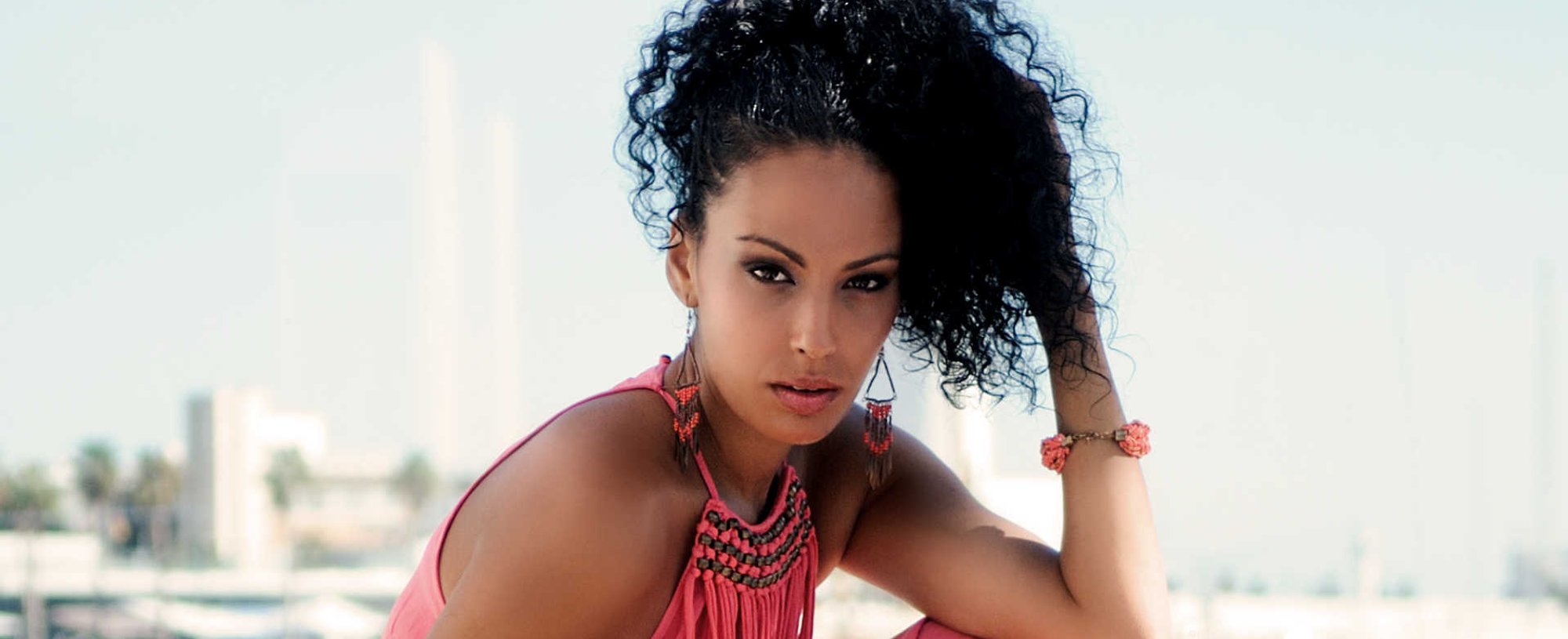 Modelo negra com cabelo cacheado posando para foto
