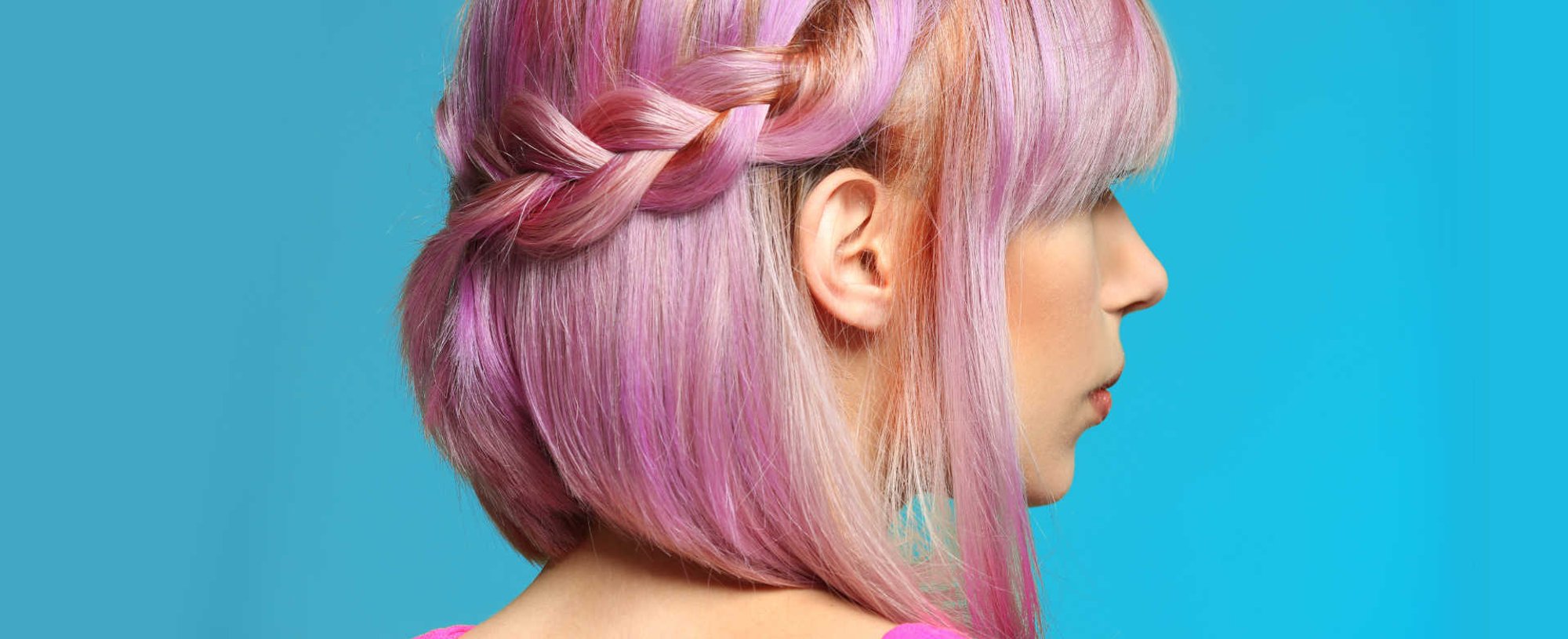 Modelo com cabelo rosa, semi preso e trançado