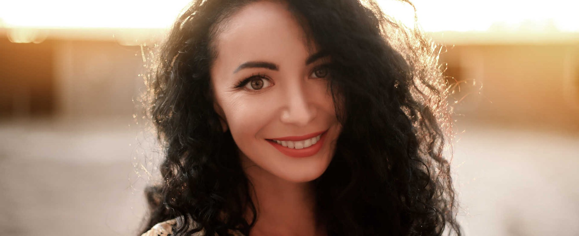 Modelo branca sorrindo com cabelo ondulado