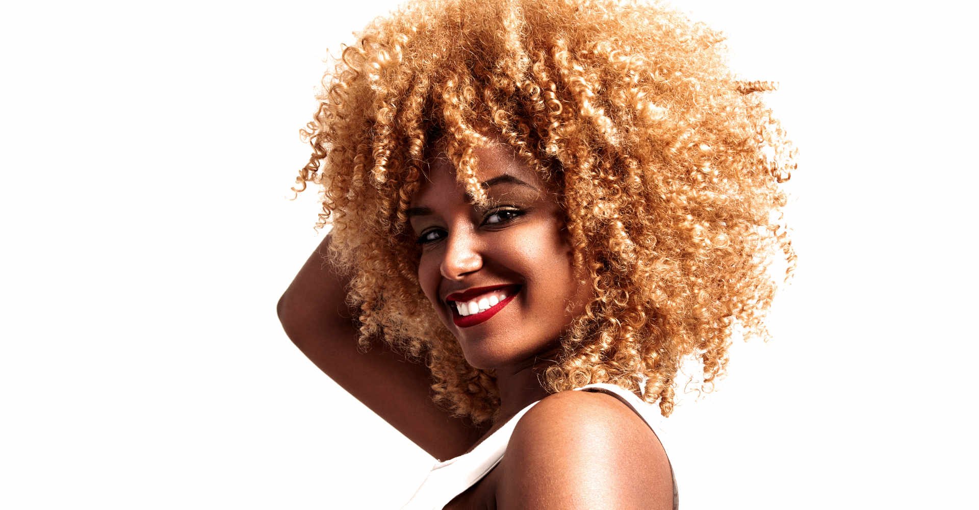 Modelo negra sorrindo com cabelo loiro