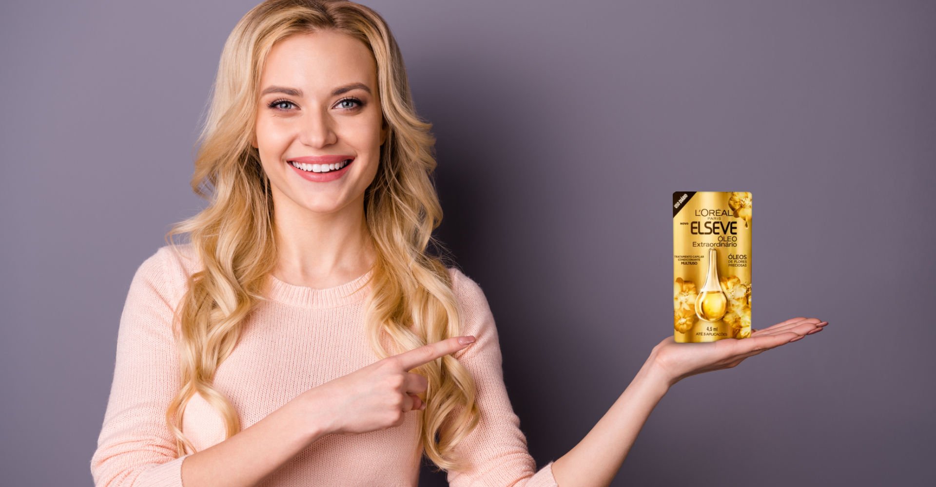 Modelo branca e loira com o produto Óleo Extraordinário na mão