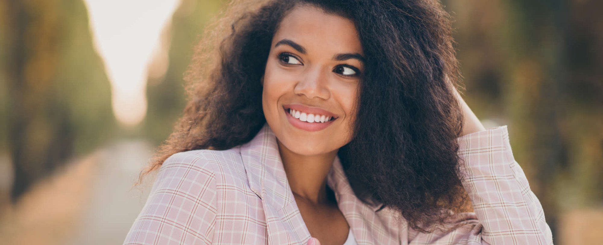 Modelo negra sorrindo com cabelo crespo