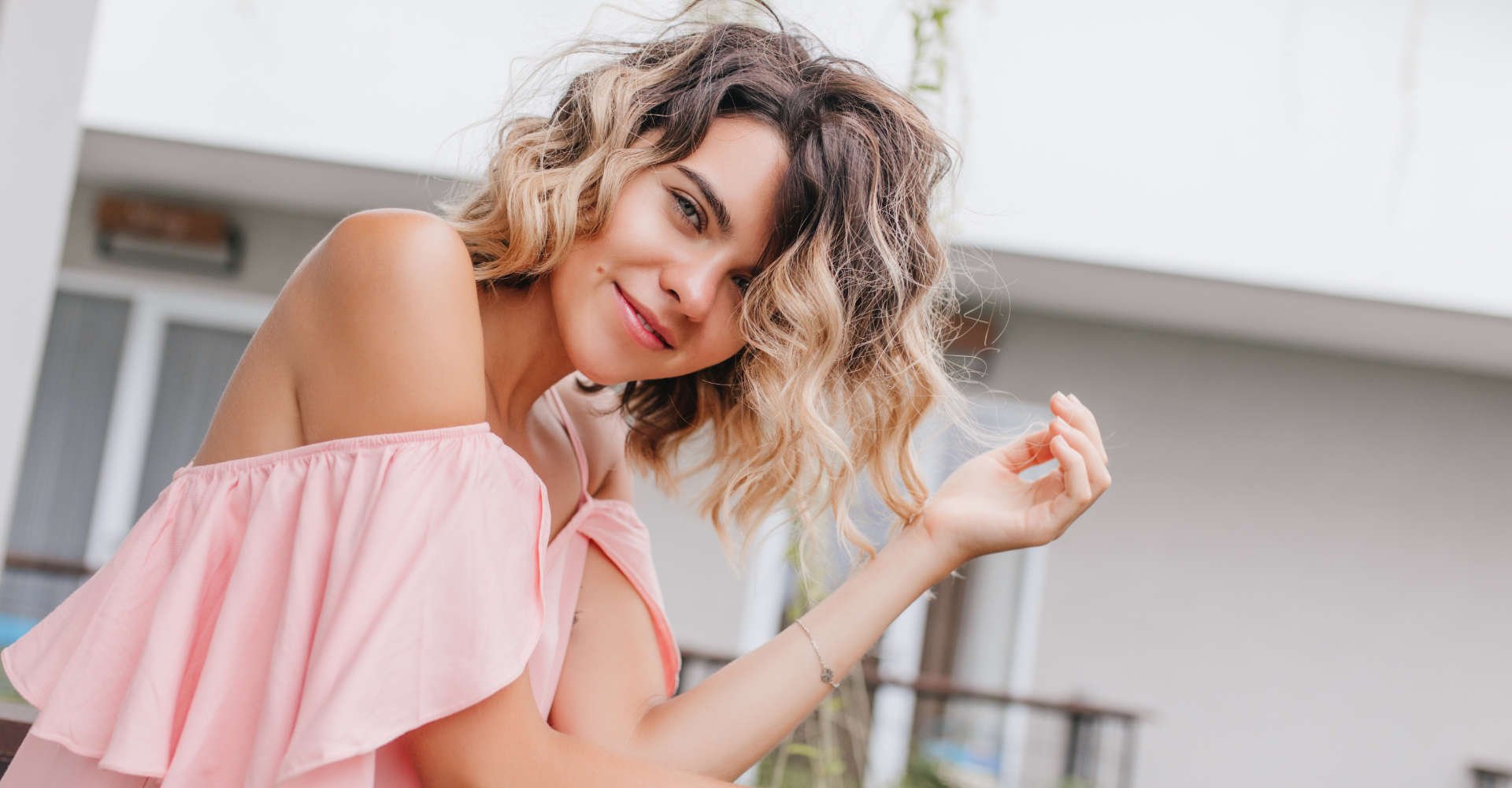 mulher exibe cabelo cacheado com mechas