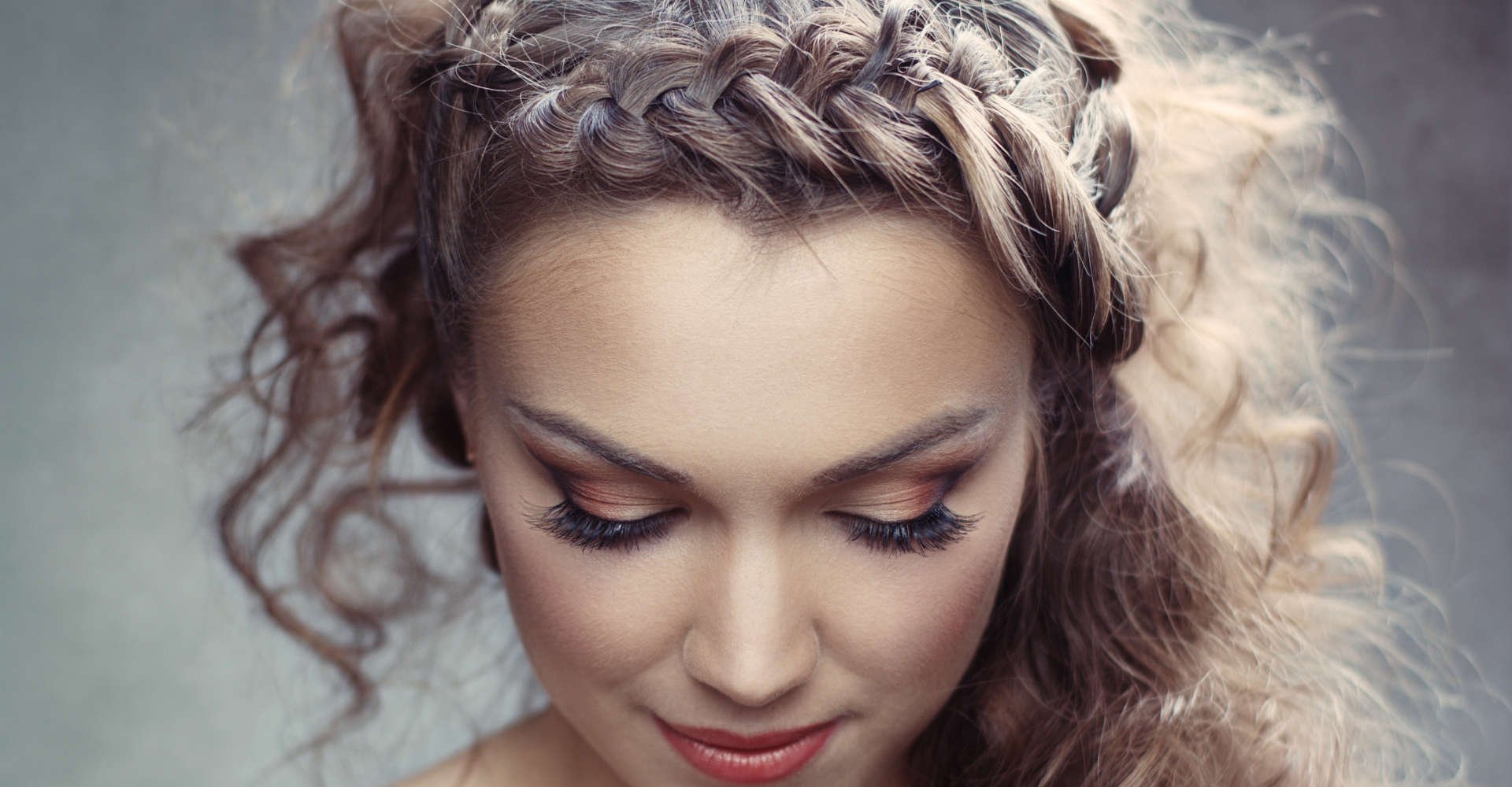 mulher exibe penteado cacheado com tranças