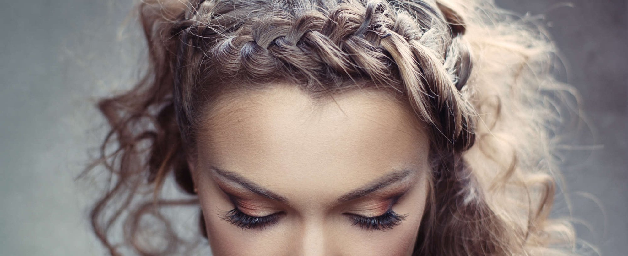 mulher exibe penteado cacheado com tranças