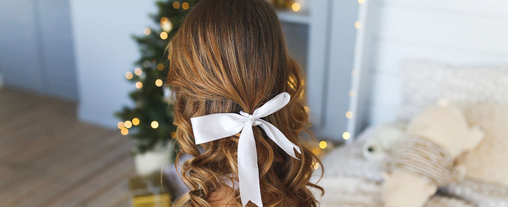 mulher exibe penteado em frente a árvore de natal