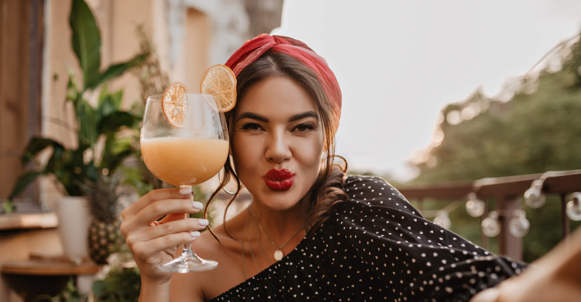 mulher com lenço no cabelo segurando um copo