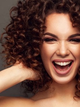 mulher exibe cabelo curto e cacheado