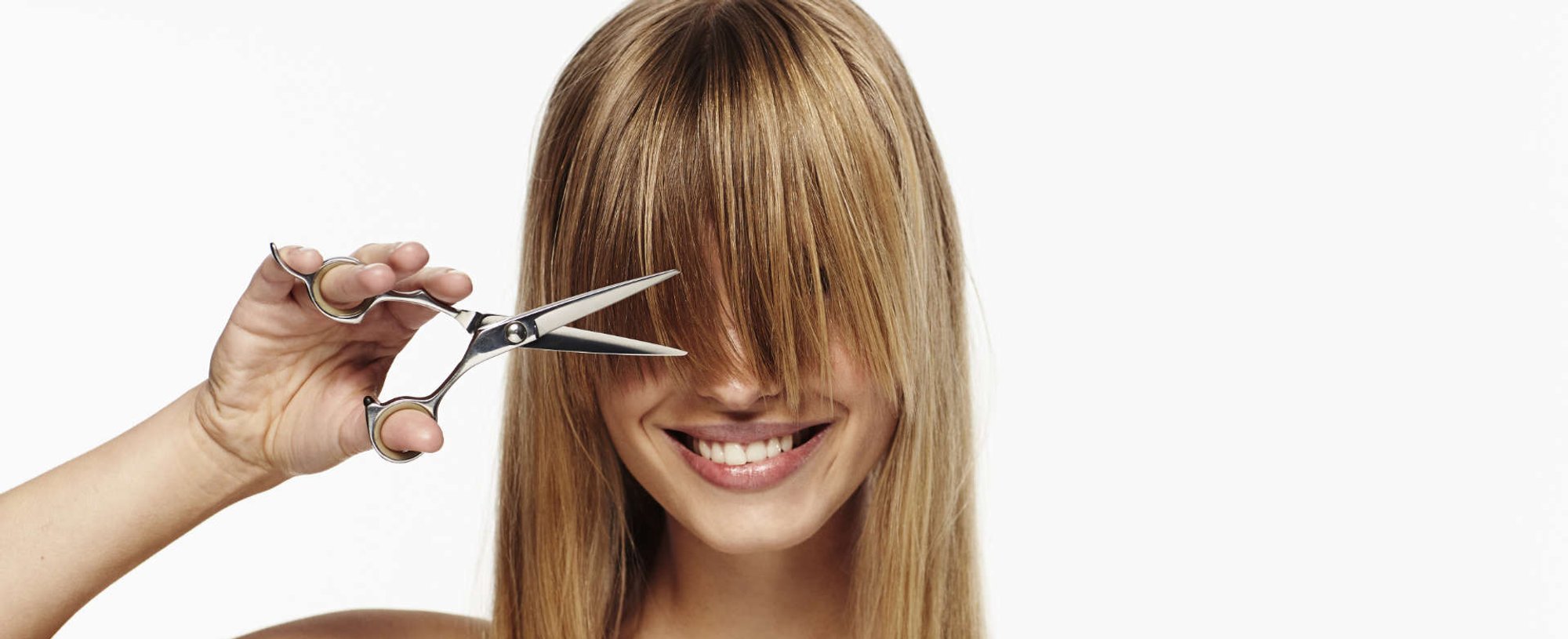 mulher cortando a franja do cabelo