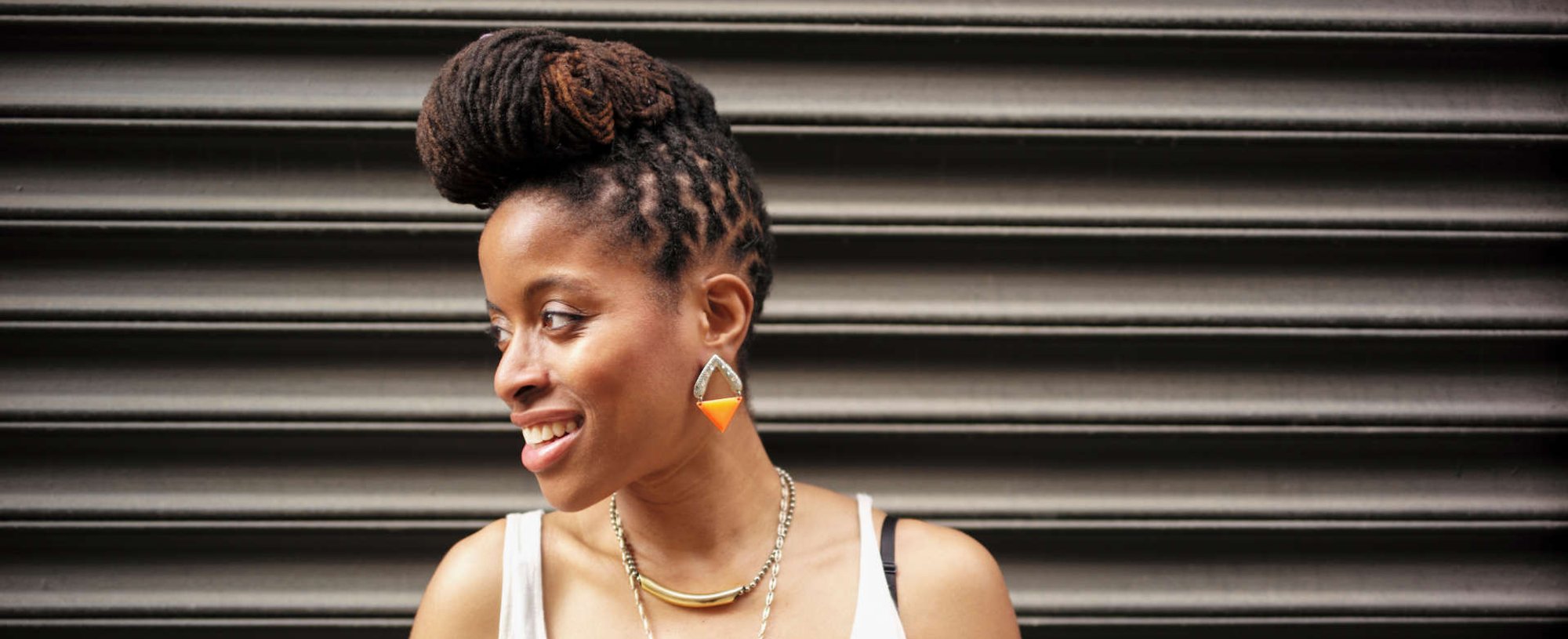 mulher exibe penteado com coque trançado alto