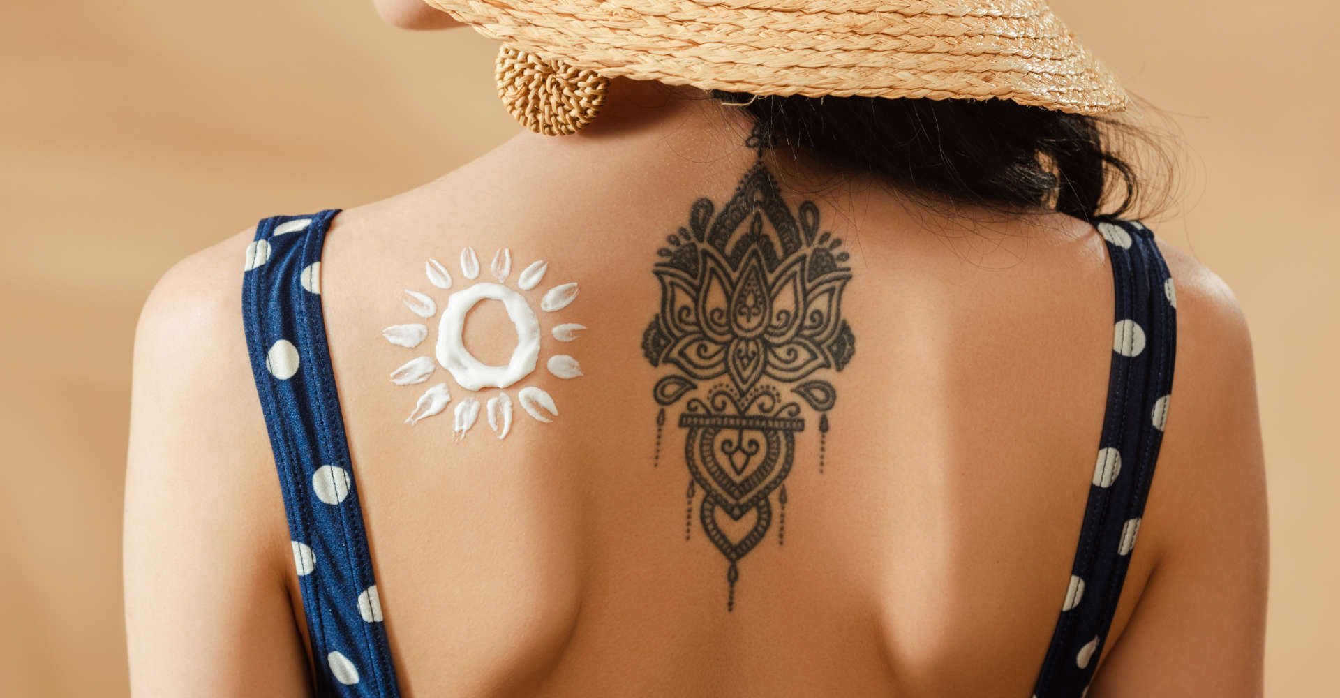 costas de uma mulher com tatuagem e ao lado protetor solar