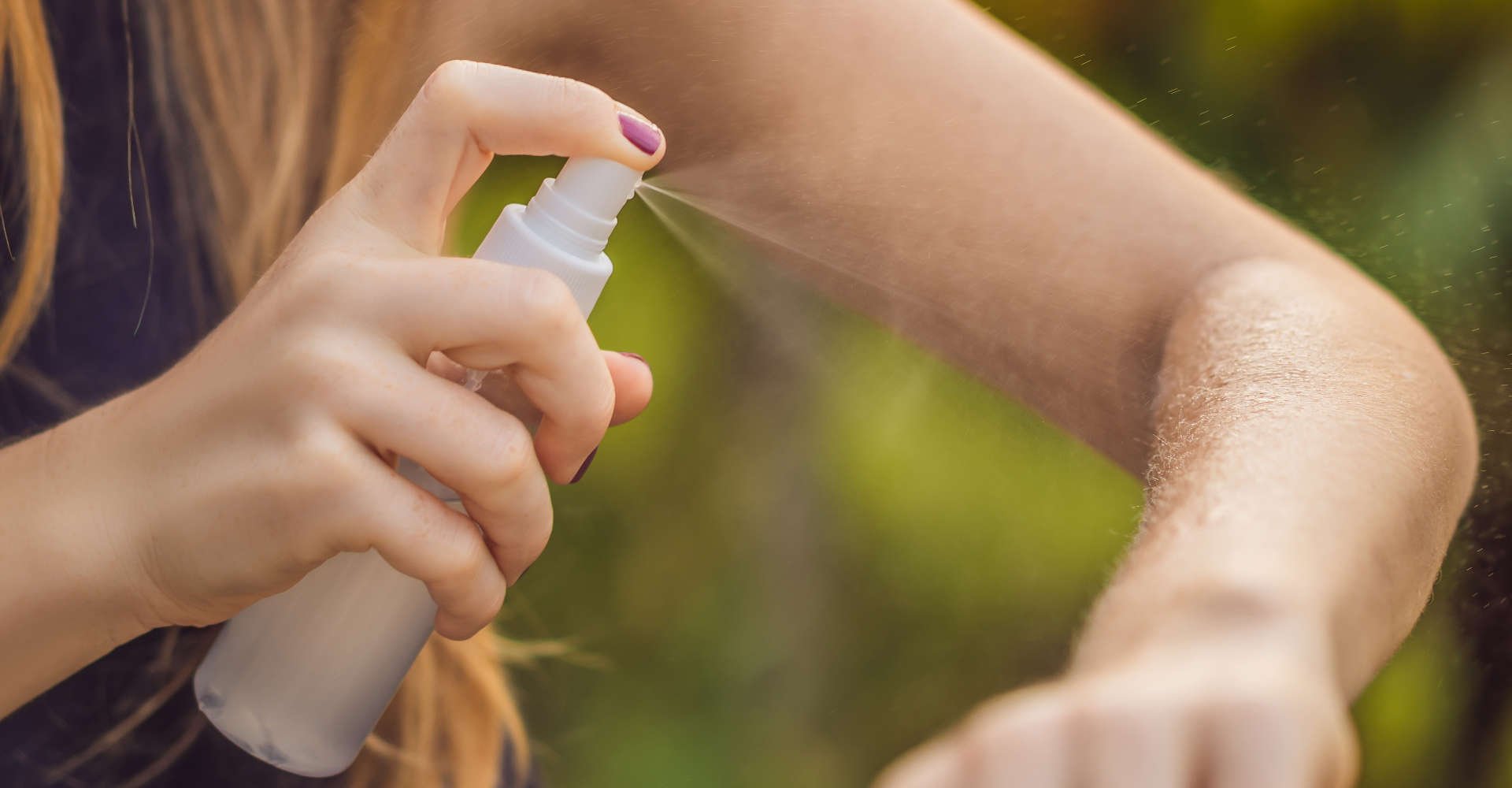 mulher passando repelente no braço