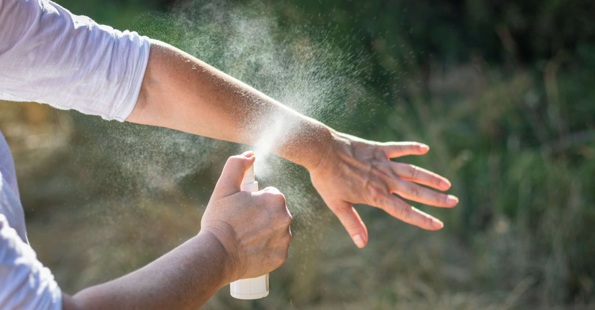 mulher passando repelente no braço