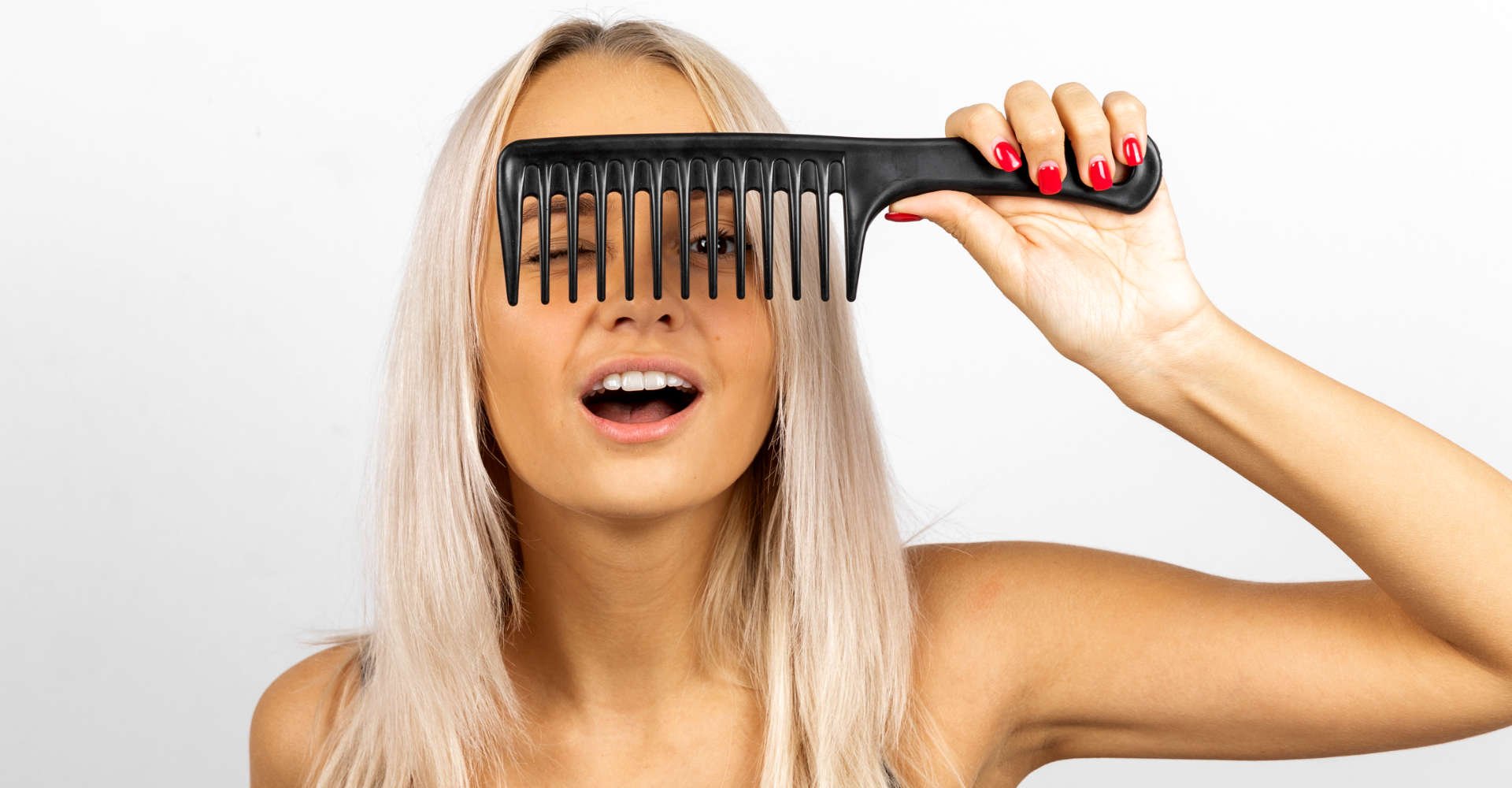 mulher exibe cabelo platinado segurando um pente na franja