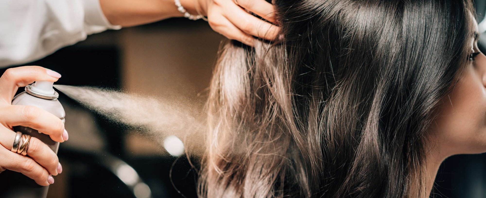 mulher passando tinta spray no cabelo