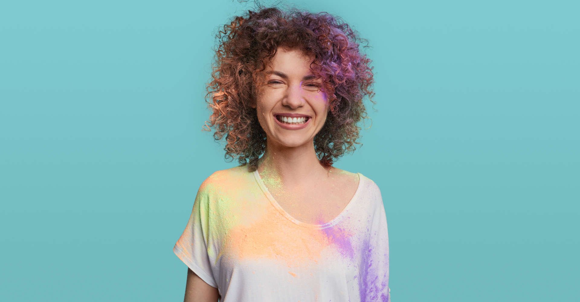 mulher com os cabelos cacheados coloridos