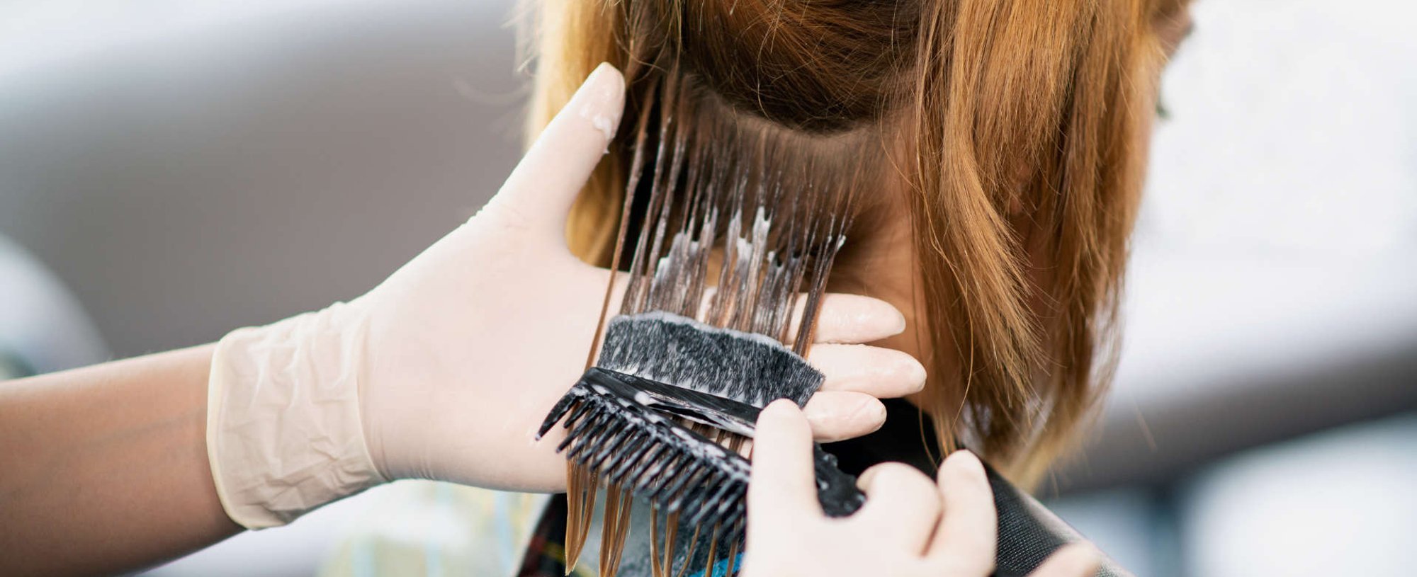 mulher divide o cabelo em partes para aplicar a coloração
