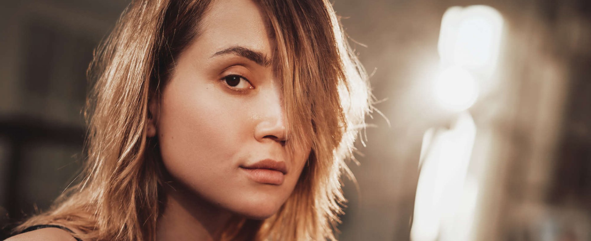 mulher exibe cabelos castanhos iluminados