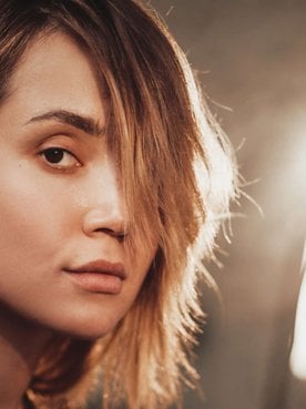 mulher exibe cabelos castanhos iluminados