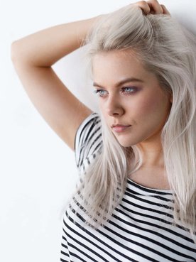 mulher exibe a coloração de seu cabelo branco platinado