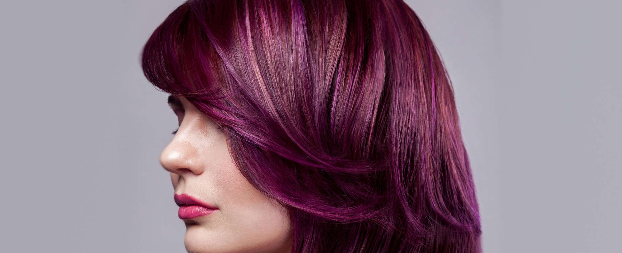 mulher exibe cabelo coloração vermelho acajú