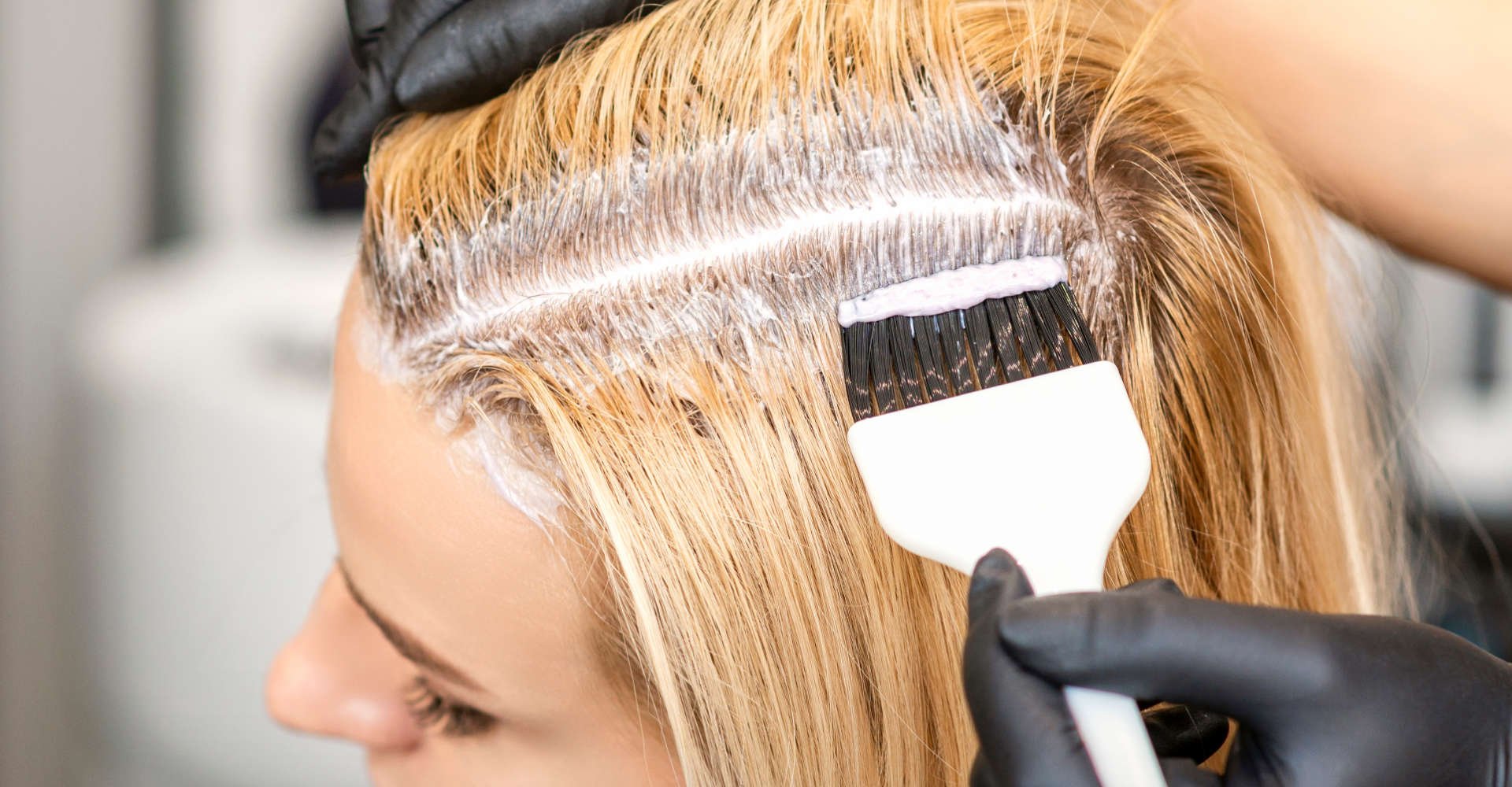 mulher pintando os cabelos de loiro