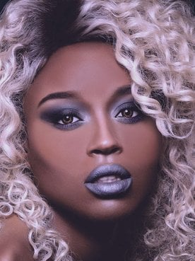 mulher exibe seus cabelo cacheado na coloração platinada