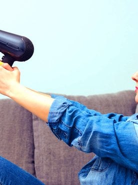 mulher segurando um secador com difusor