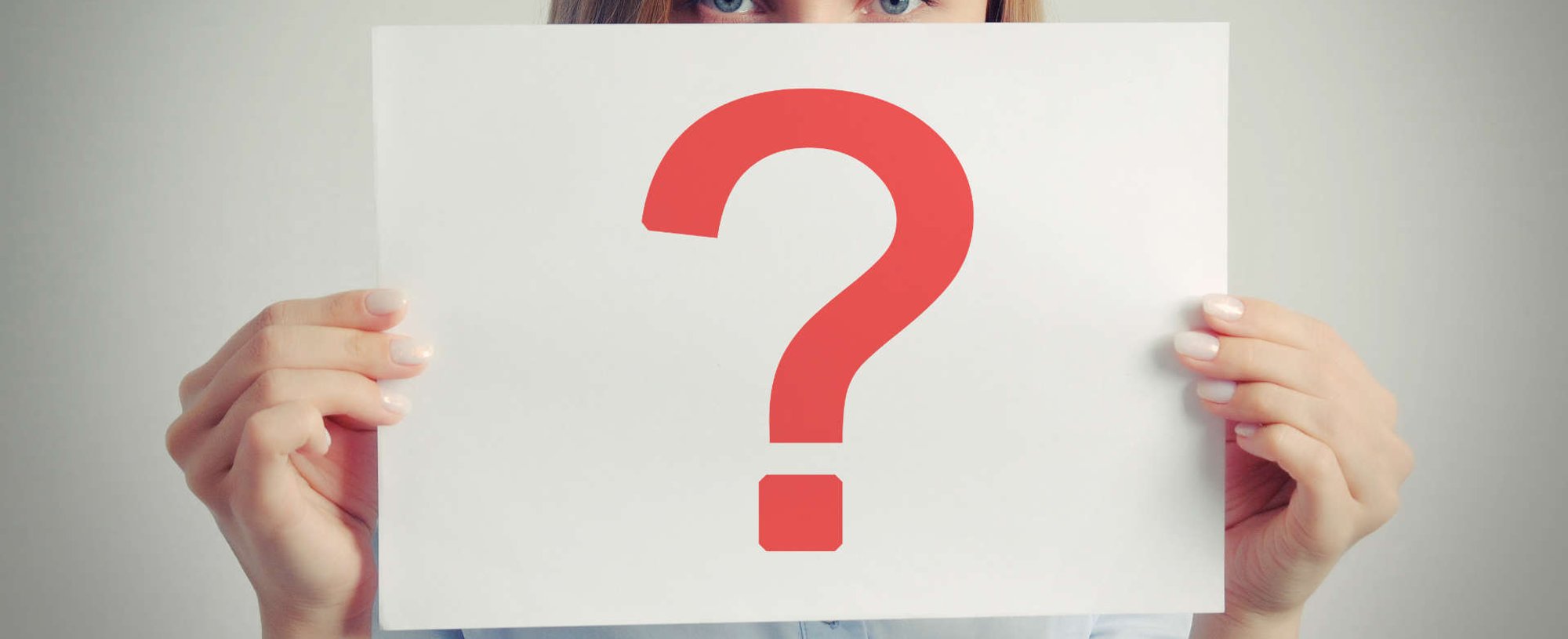 mulher exibe cartaz com um ponto de interrogação