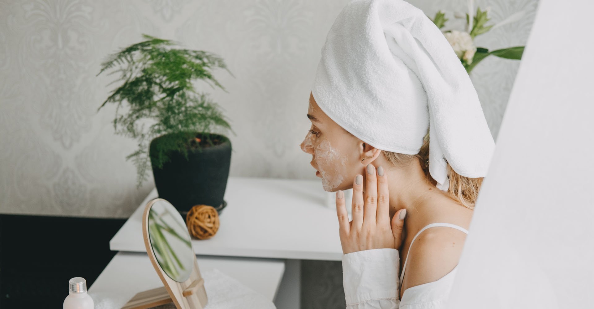 Modelo se olhando no espelho passando a mão no rosto