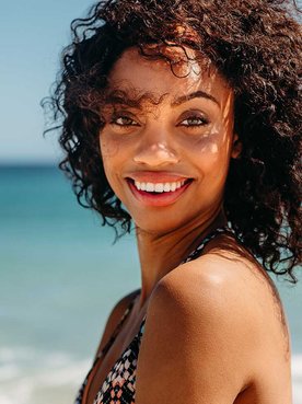 Modelo Morena Com Cabelo Cacheado Sorrindo Na Praia