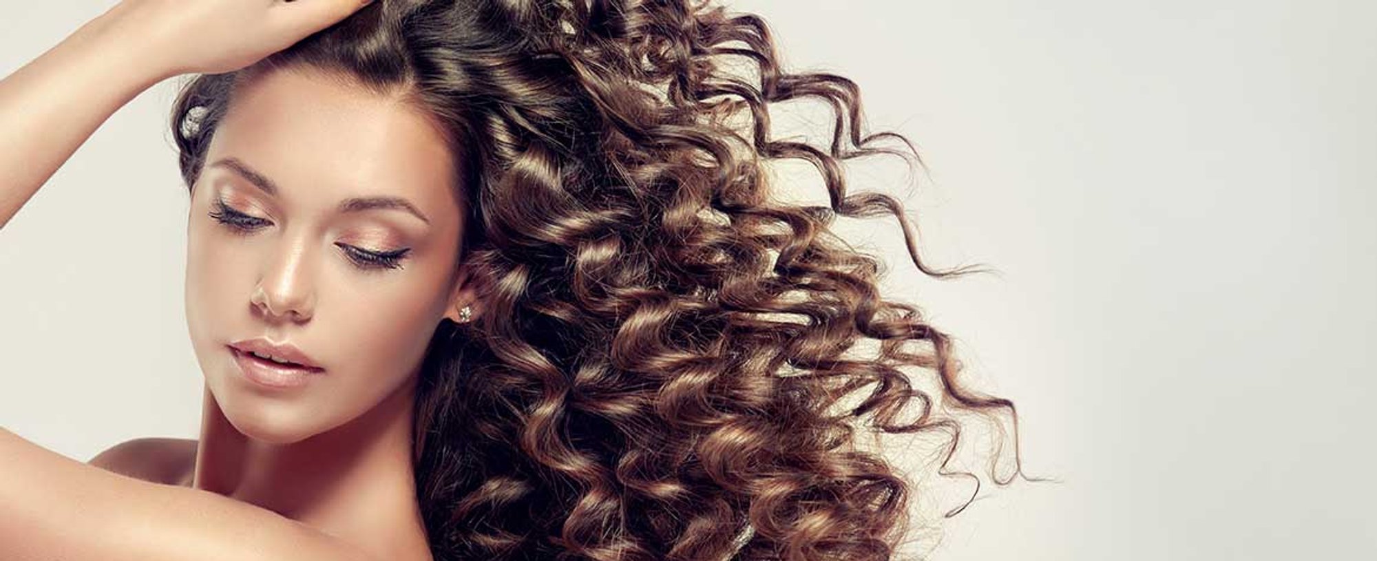 Modelo morena com lindos cabelos cacheados volumosos e longos