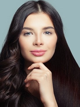 Modelo branca de olhos claros e cabelo preto comprido. Um lado liso e o outro ondulado